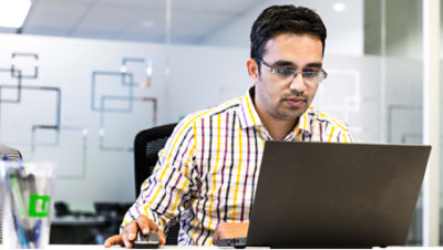 A person sitting and using his laptop