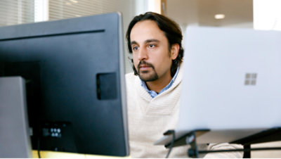 A man is sitting and looking into computer screen