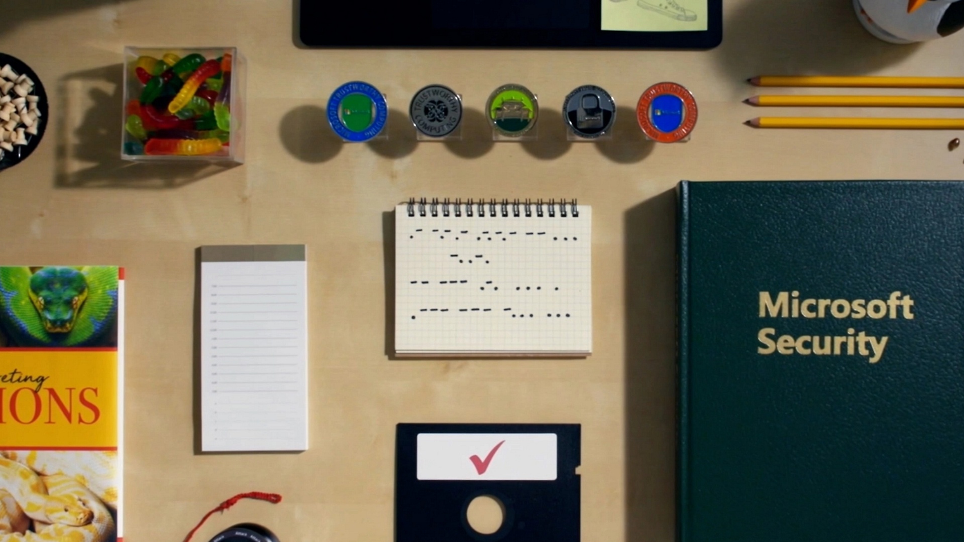 Items organized on a desk such as candy, notepads, a floppy disk and more
