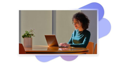 A person sitting at a table using a laptop.