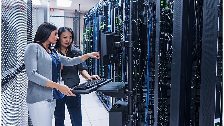 Two women working in a server room.