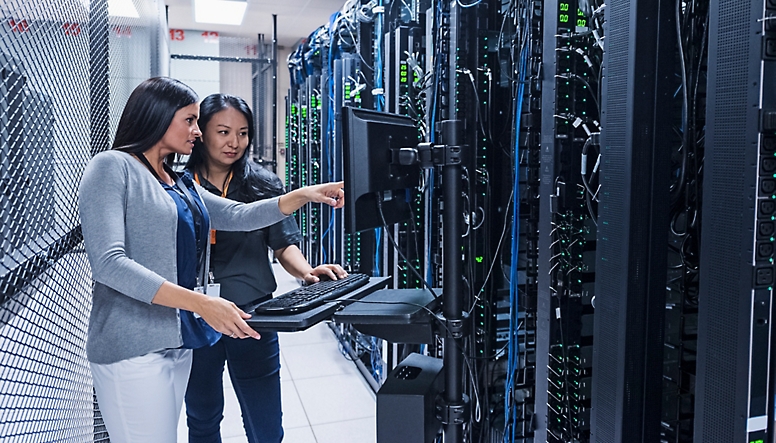 Two women working in a server room.