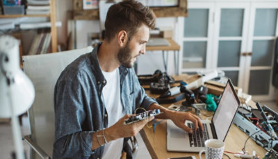 A man working on a laptop in his home office.