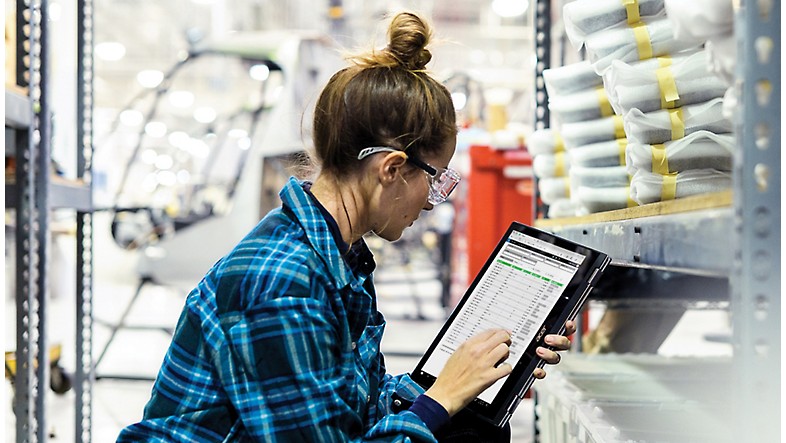 Femme utilisant une tablette dans un entrepôt.
