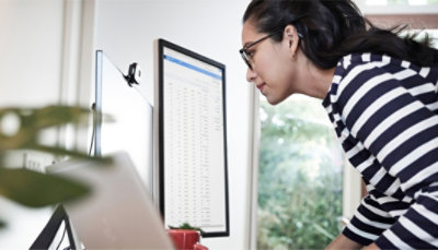 Frau schaut einen Bildschirm Daten an