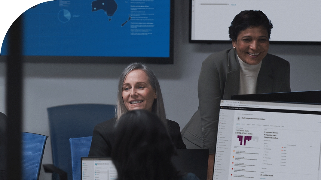 שתי נשים מחייכות ועובדות במשרד.