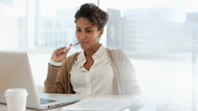 A person sitting at their desk using a laptop
