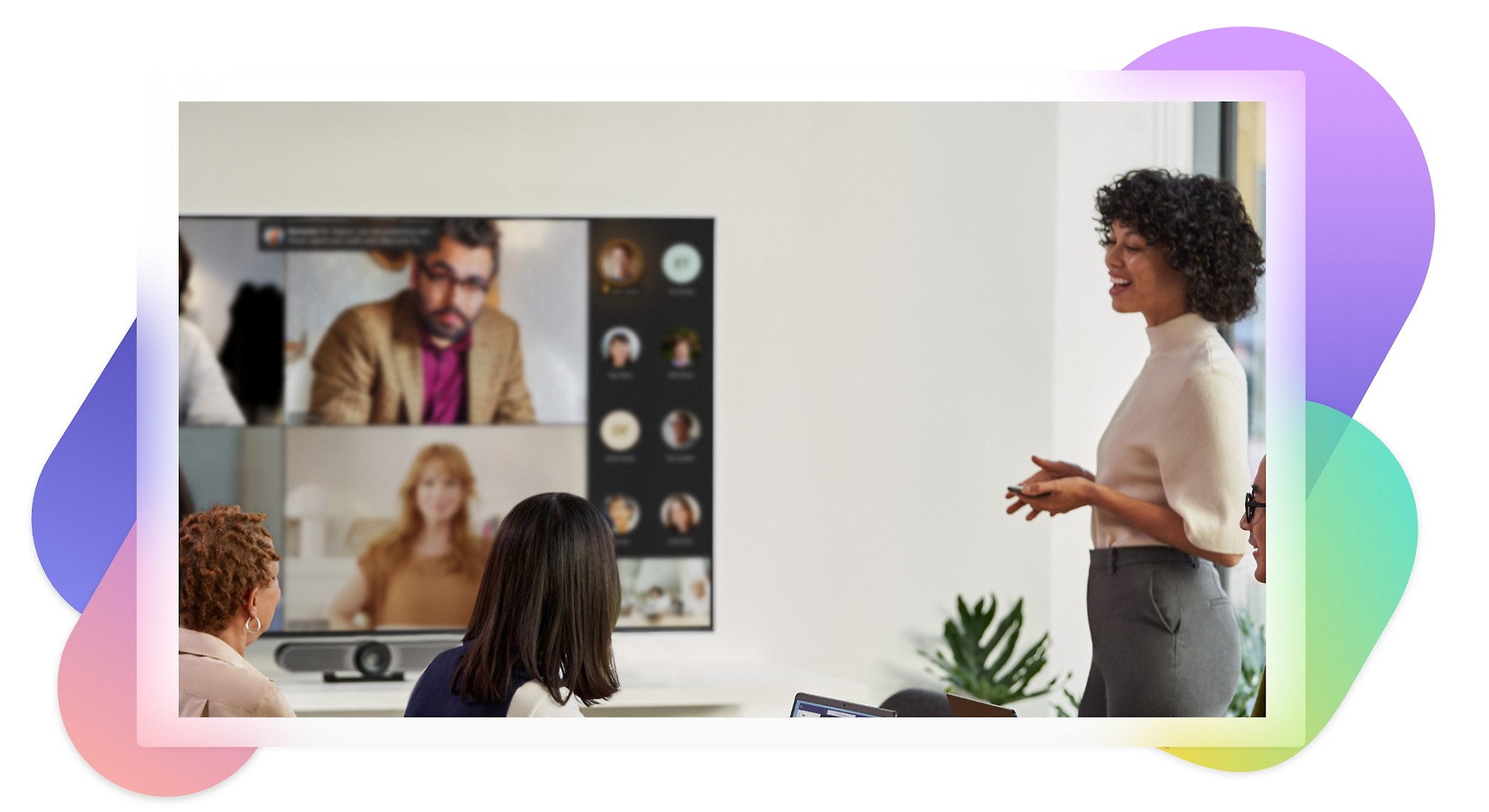 Några personer i ett mötesrum som deltar i ett Teams Premium-videosamtal som visas på en stor TV på väggen.