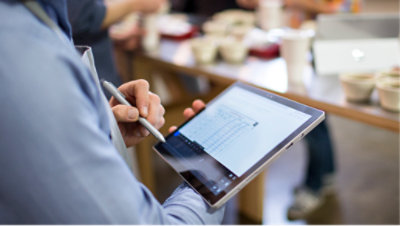 A person working on his tablet with stylus