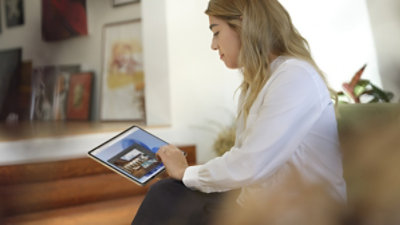 A person sitting on a couch using a tablet