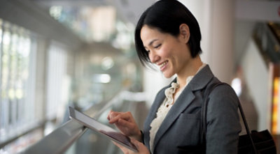 A person smiling and using a tablet 