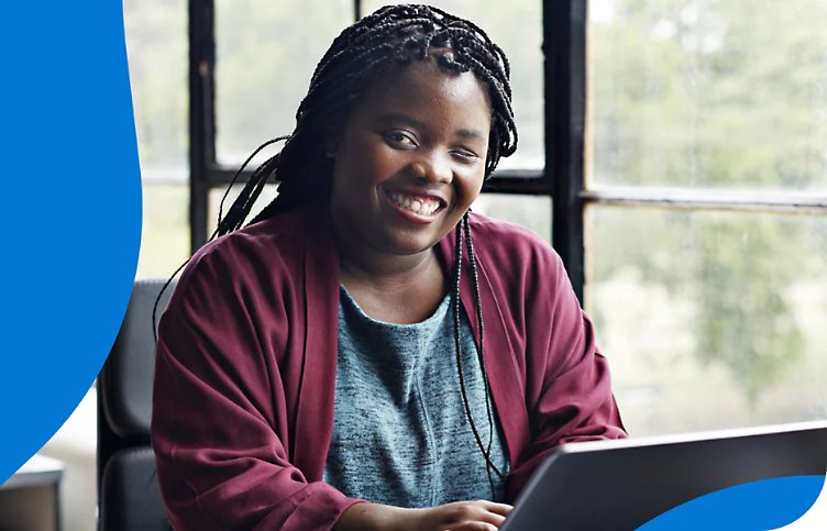 A disabled person smiling and using a laptop.