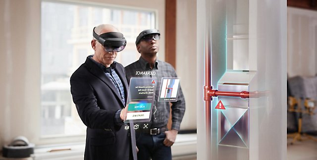 Two people wearing HoloLens 2 to view machinery in virtual reality