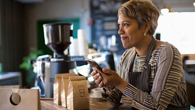 A woman server in coffee house using her mobile
