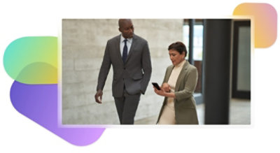 Dos personas caminan por un pasillo y una de ellas utiliza un teléfono móvil.