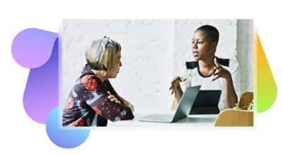 Dos personas conversando con un portátil.