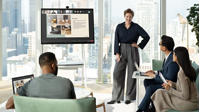 A presentation being shown on the screen while others take notes of it