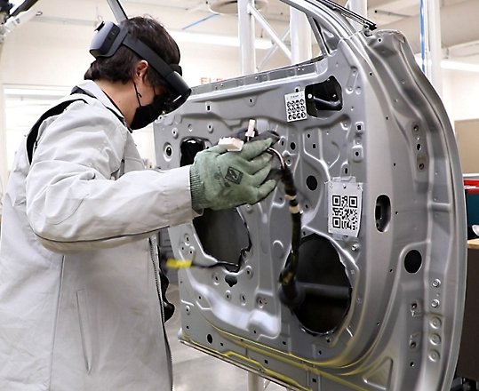 A person building a vehicle while wearing HoloLens 2.