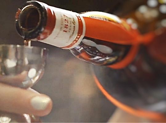 Točenje alkoholne pijače v majhno kovinsko skodelico