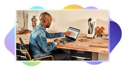 A person sitting at their desk using Outlook on their laptop.