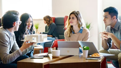 En grupp arkitekter kikar på en 3D-modell på ett bord