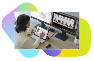A person working at their desk with a tablet and two desktop monitors displaying architectural designs and a Teams call in Together mode simulating all of the participants sitting together at a table