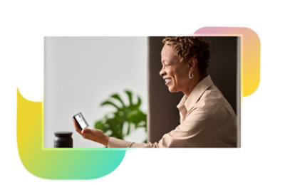 A person smiling and holding their phone up horizontally