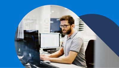 一個人正在使用顯示 Outlook 的膝上型電腦工作，該電腦連接到兩部顯示資料的桌上型監視器