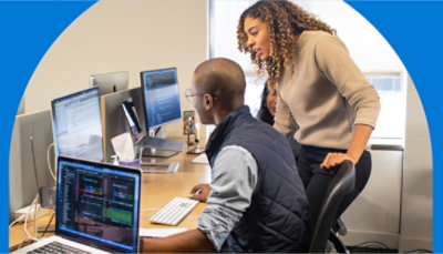 會議室裡的人員正與另一間會議室裡圍坐在桌子旁的人員進行視訊會議