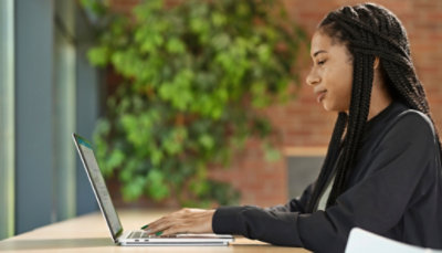A young woman using a laptop in an office.