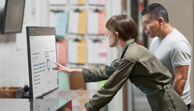 A man and woman looking at a computer screen.