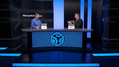 A screenshot from the SQL Server 2022 Microsoft Mechanics video with the two speakers sitting at a desk having a conversation