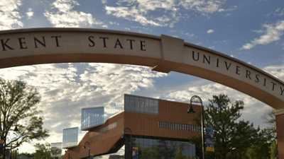 A stone archway that says Kent State University leading onto campus