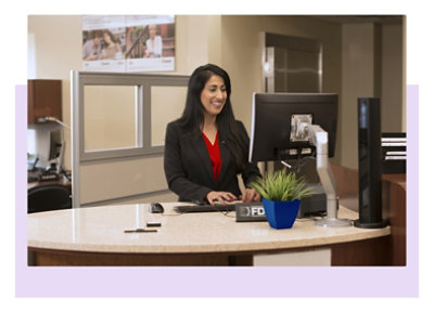 Seorang teller bank sedang bekerja di meja kerja.