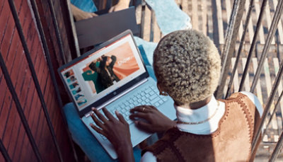 Una persona che scrive a un portatile con diapositive di PowerPoint