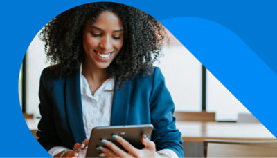A person standing over a desk typing on a keyboard.
