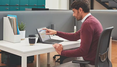 A man sitting at a desk using a laptop.