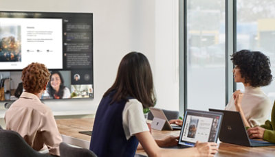 Tre persone in una sala riunioni impegnate in una videochiamata su Teams durante una presentazione