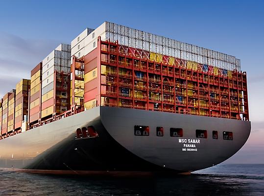 Een groot vrachtschip met duizenden vrachtcontainers erop