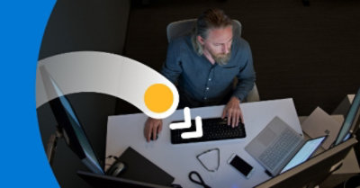 Homme travaillant à un bureau et regardant un écran. 