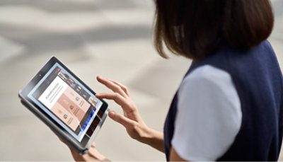 A woman is holding a tablet in her hands.