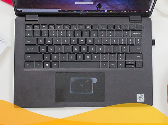 A top-down view of a laptop keyboard and a hand resting on a mouse 