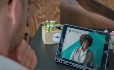 Un cliente ve un vídeo de un empleado de ABN AMRO en una tableta.