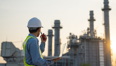 Travailleur portant un casque et gilet de sécurité et utilisant un talkie-walkie sur un chantier