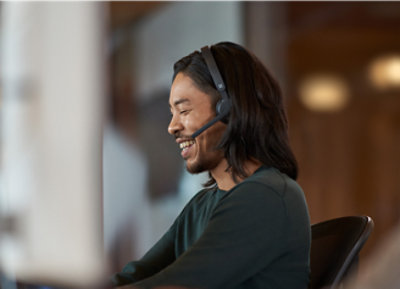 Una persona con auriculares y sonriendo.