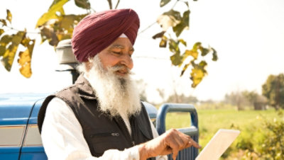 Osoba venku před nákladním autem, která používá tablet