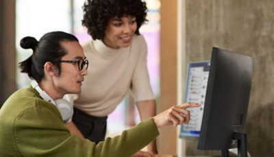 Due persone che guardano i monitor di alcuni computer