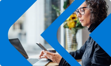 Una persona usa un teléfono móvil y un portátil.