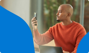 Una persona sostiene su teléfono móvil al nivel de los ojos para usarlo.