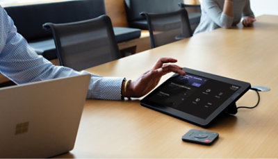 A man is using a tablet at a conference table.